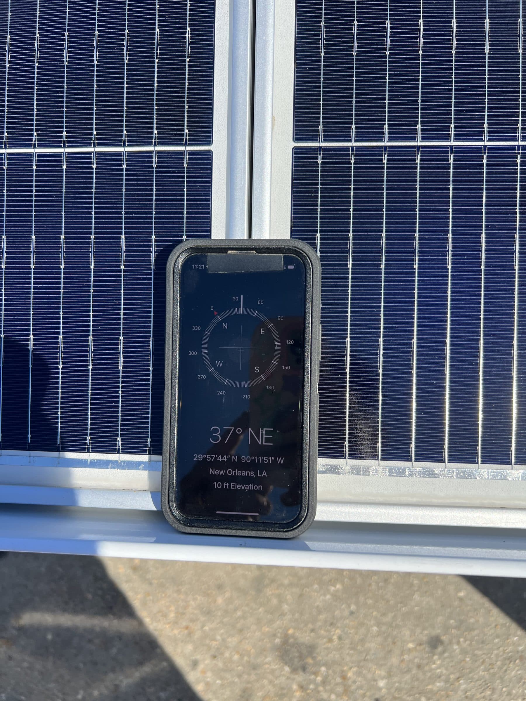 Phone compass reading New Orleans, LA, resting on the solar panel of a SolarCam360 install in New Orleans